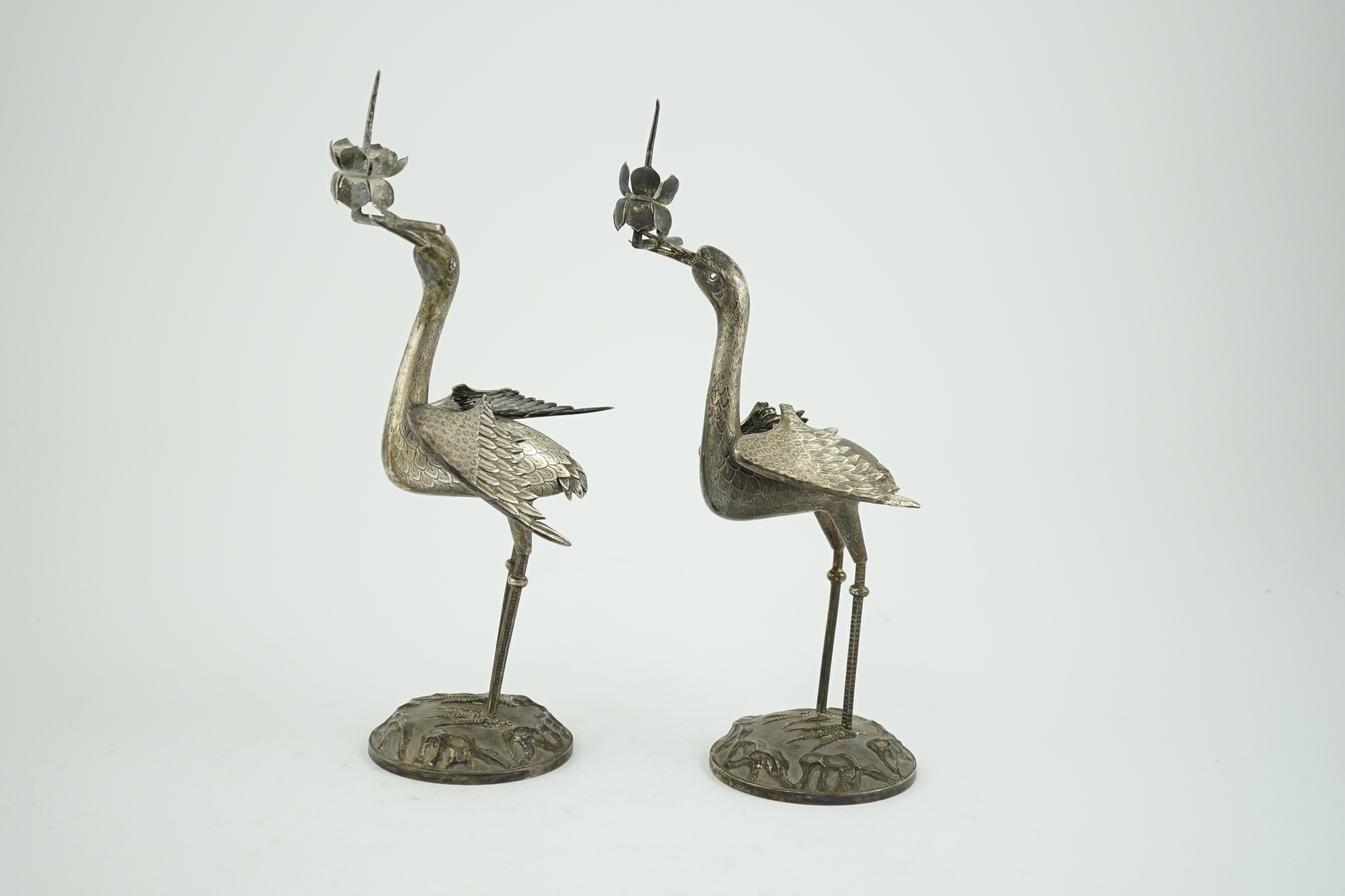 A pair of early to mid 20th century Japanese silver candlesticks, modelled as cranes